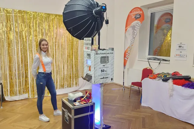 Hosté při focení před zlatým pozadím na plese
